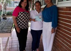 Directora Nacional de Jóvenes y Adultos, Magíster Agnes de Cotes y la Supervisora Regional de Panamá Centro, Magíster Emelda Guerra, haciendo entrega de un presente a la encargada de la Casa Ave María